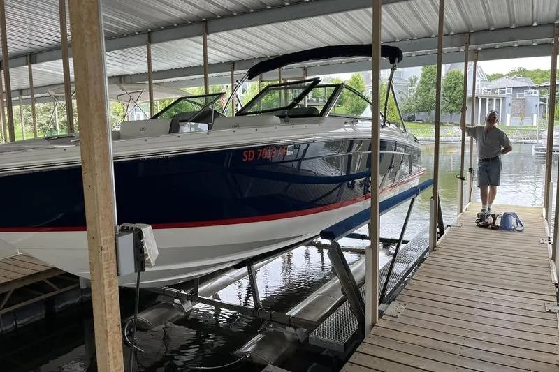 Slide: The Image of 2022 Cobalt R4 boat docked in a covered marina with a person standing nearby. - 5