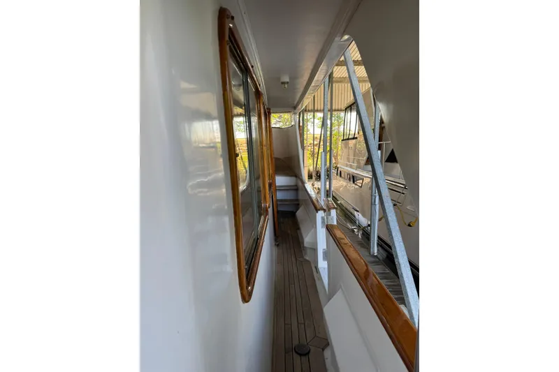 Slide: The Image of 1979 De Fever Pilot House yacht deck with wooden railings and windows. - 13