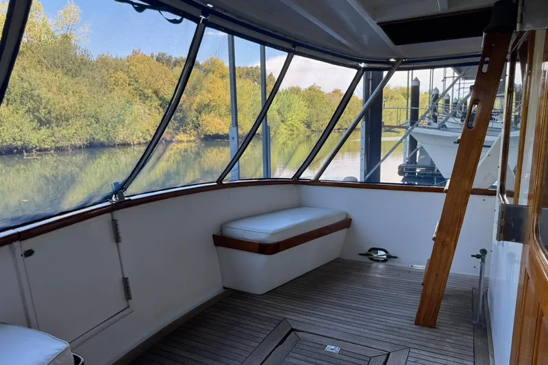 Slide: The Image of 1979 De Fever Pilot House boat interior with wooden deck and cushioned seating. - 19