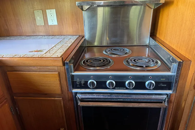 Slide: The Image of 1979 De Fever Pilot House kitchen with electric stove and wooden cabinetry. - 30