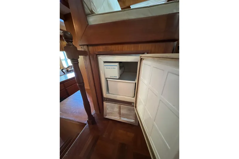 Slide: The Image of 1979 De Fever Pilot House interior with open U-Line ice maker, wooden cabinetry. - 31