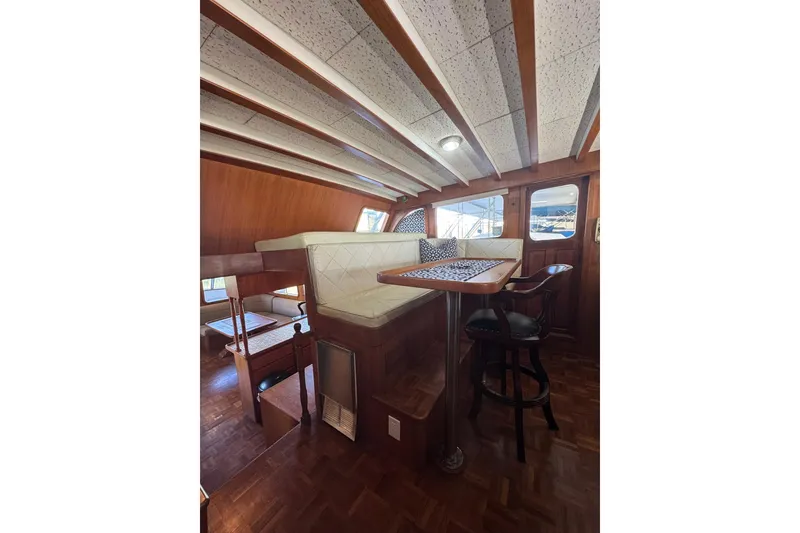 Slide: The Image of 1979 De Fever Pilot House interior with wood paneling, cushioned seating, and dining area. - 32