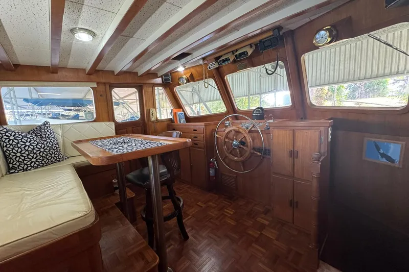 Slide: The Image of 1979 De Fever Pilot House interior with wooden helm, seating, and nautical decor. - 33