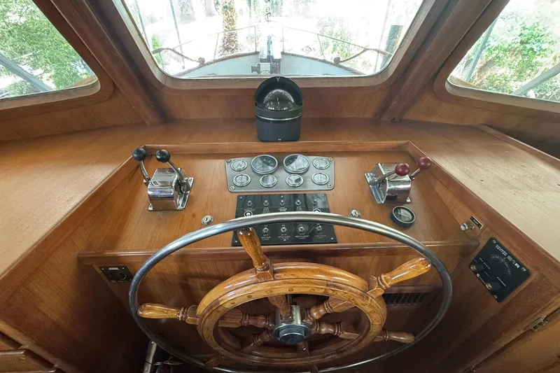 Slide: The Image of 1979 De Fever Pilot House interior with wooden steering wheel and control panel. - 36