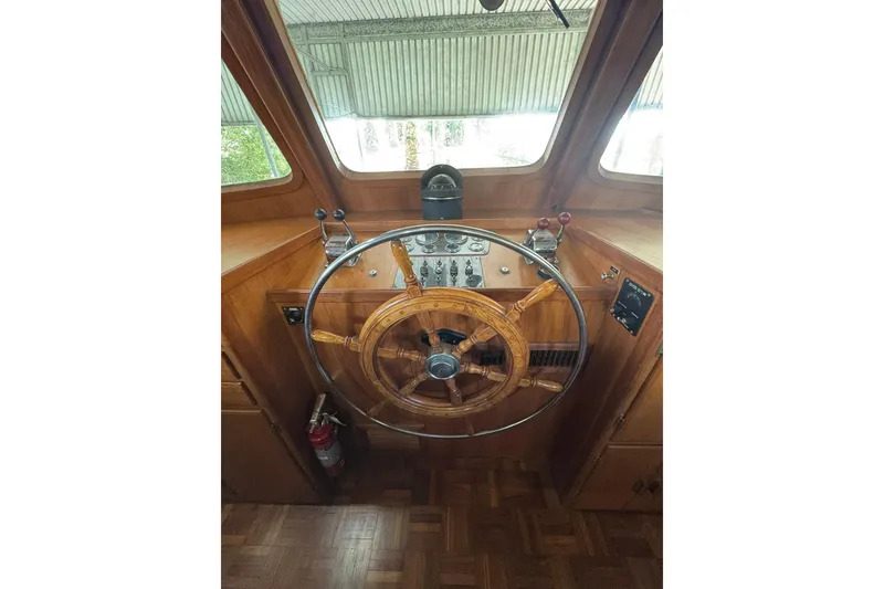 Slide: The Image of 1979 De Fever Pilot House interior with wooden steering wheel and control panel. - 37