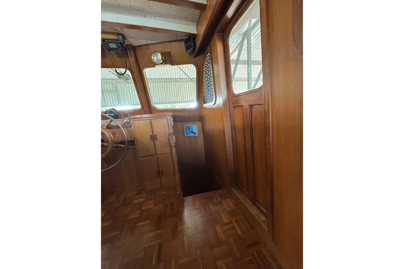 Slide: The Image of 1979 De Fever Pilot House interior with wooden paneling and steering wheel. - 39