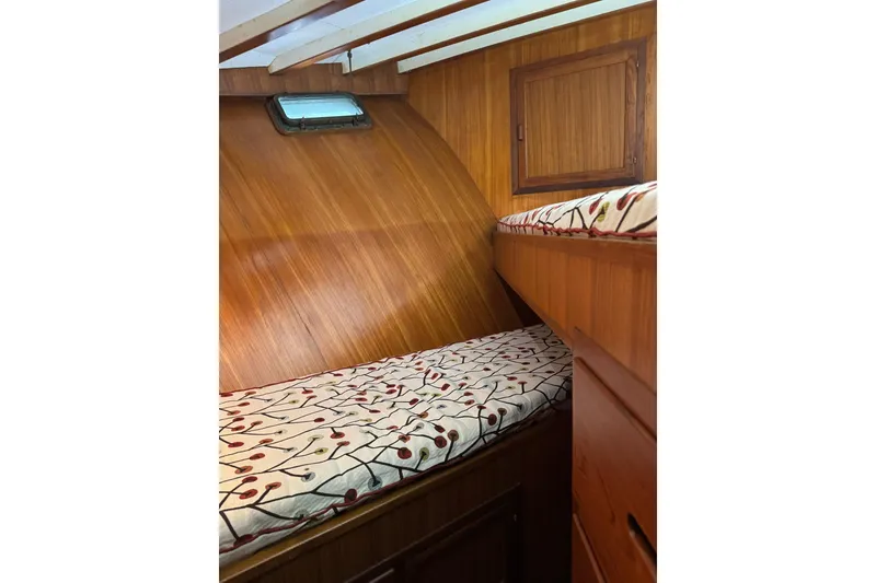 Slide: The Image of 1979 De Fever Pilot House interior with wooden paneling and patterned bedding. - 44