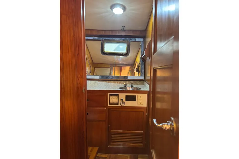 Slide: The Image of 1979 De Fever Pilot House interior with wooden cabinetry and compact sink area. - 46