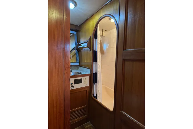 Slide: The Image of 1979 De Fever Pilot House bathroom with wood paneling and shower curtain. - 48