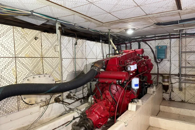 Slide: The Image of Engine room of a 1979 De Fever Pilot House with red machinery and wiring. - 52