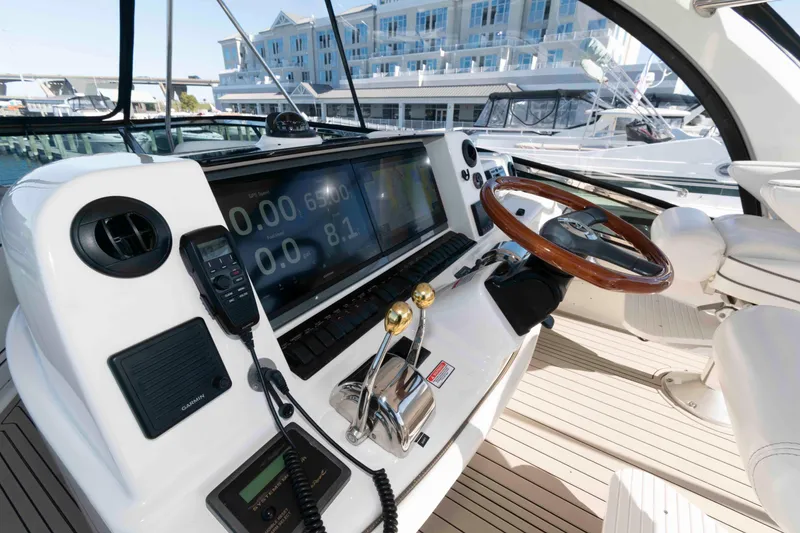 Slide: The Image of 2006 Sea Ray 52 Sedan Bridge helm with modern navigation equipment and wooden steering wheel. - 11