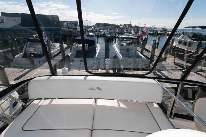 Slide: The Image of 2006 Sea Ray 52 Sedan Bridge yacht docked at a marina with clear skies. - 16