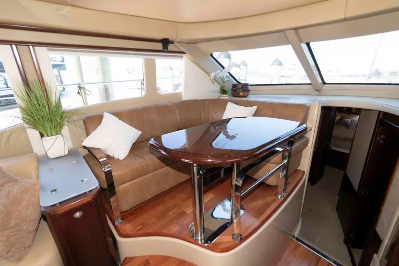 Slide: The Image of Luxurious interior of 2006 Sea Ray 52 Sedan Bridge with elegant seating and polished wood table. - 25