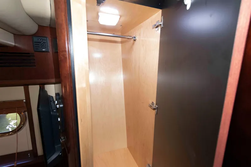 Slide: The Image of Interior closet of 2006 Sea Ray 52 Sedan Bridge yacht, featuring wooden finish and lighting. - 33