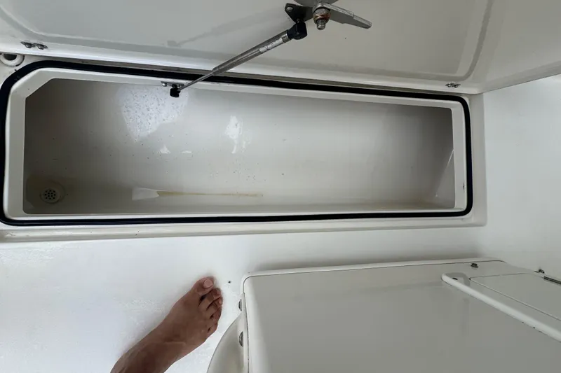 Slide: The Image of Open storage compartment on 2014 Cobia 296 Center Console boat deck. - 11