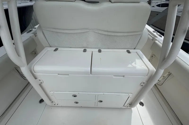 Slide: The Image of 2014 Cobia 296 Center Console boat interior with white seating and storage compartments. - 14