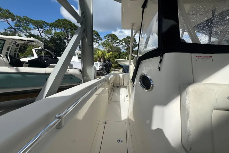 Slide: The Image of 2014 Cobia 296 Center Console boat docked, featuring sleek design and spacious deck. - 19