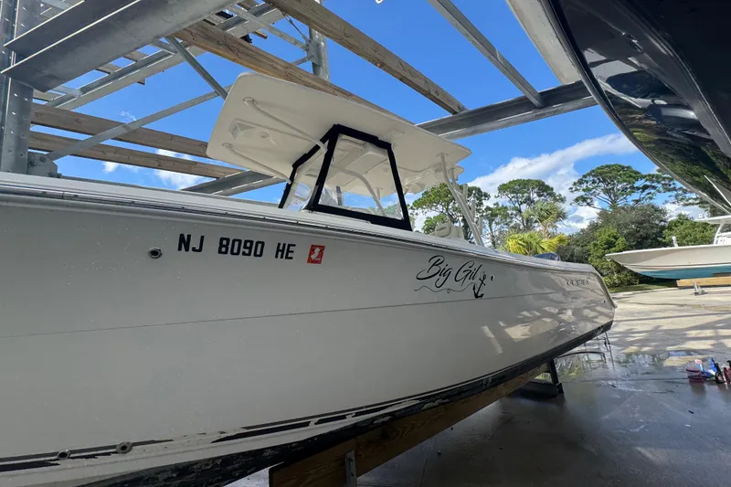 Slide: The Image of 2014 Cobia 296 Center Console boat on dry dock under blue sky. - 2