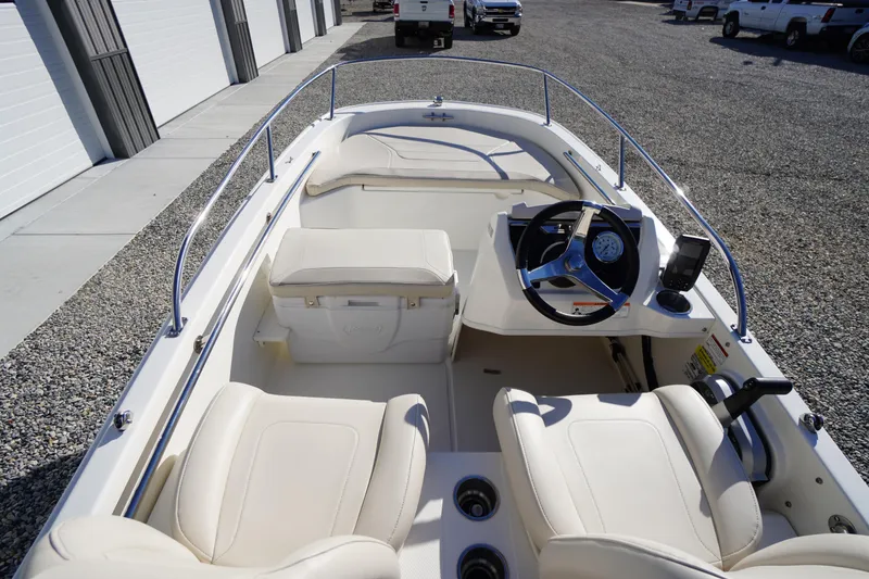 Slide: The Image of 2023 Boston Whaler 130 Super Sport interior with steering wheel and seating. - 22
