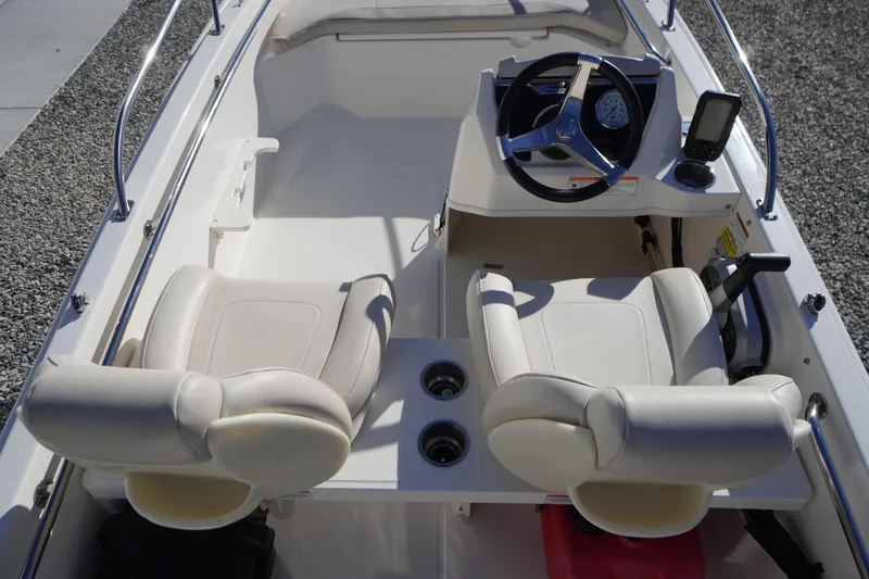 Slide: The Image of 2023 Boston Whaler 130 Super Sport interior with dual seats and steering console. - 24