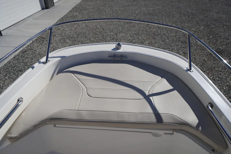 Slide: The Image of 2023 Boston Whaler 130 Super Sport boat bow with cushioned seating and stainless steel railing. - 25