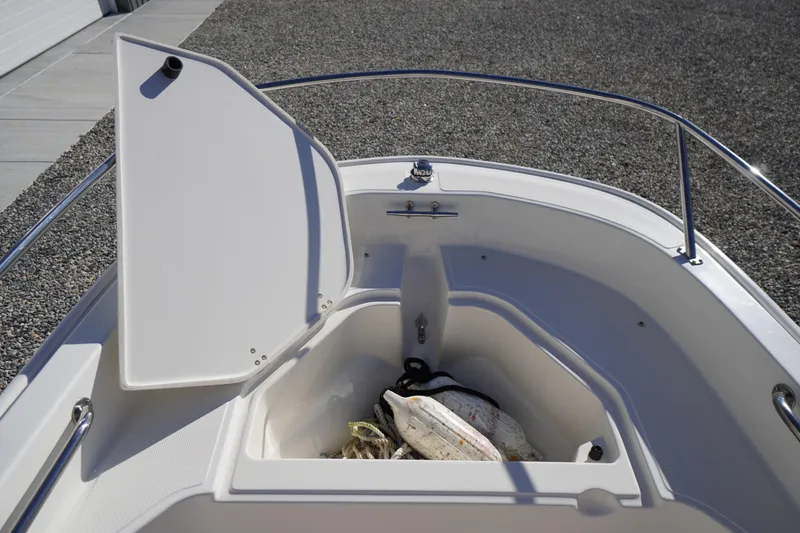 Slide: The Image of Open storage compartment on 2023 Boston Whaler 130 Super Sport boat, showing interior space. - 27