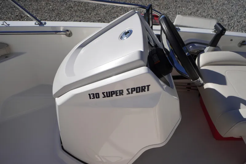 Slide: The Image of 2023 Boston Whaler 130 Super Sport boat interior with steering wheel and seating. - 28
