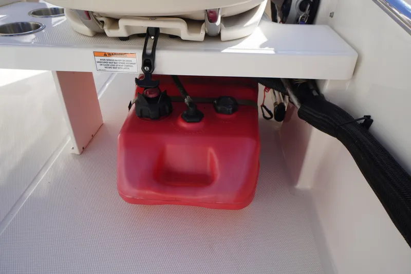 Slide: The Image of 2023 Boston Whaler 130 Super Sport boat interior with red fuel tank under seat. - 30
