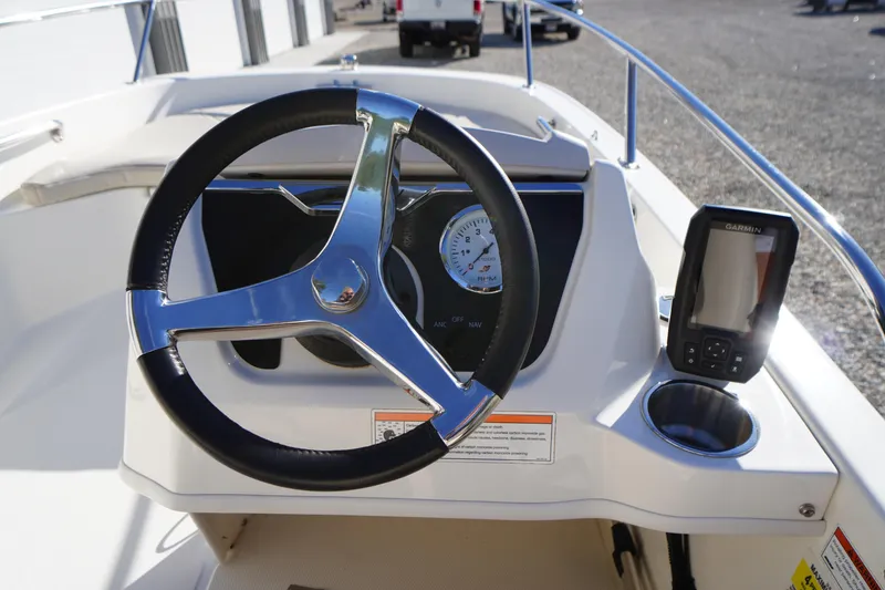 Slide: The Image of 2023 Boston Whaler 130 Super Sport dashboard with steering wheel and Garmin device. - 31