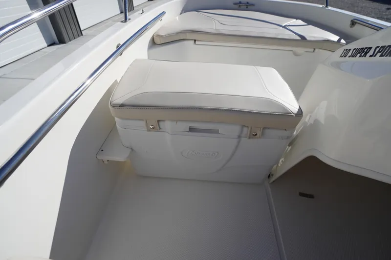 Slide: The Image of 2023 Boston Whaler 130 Super Sport interior with cushioned seating and storage. - 36