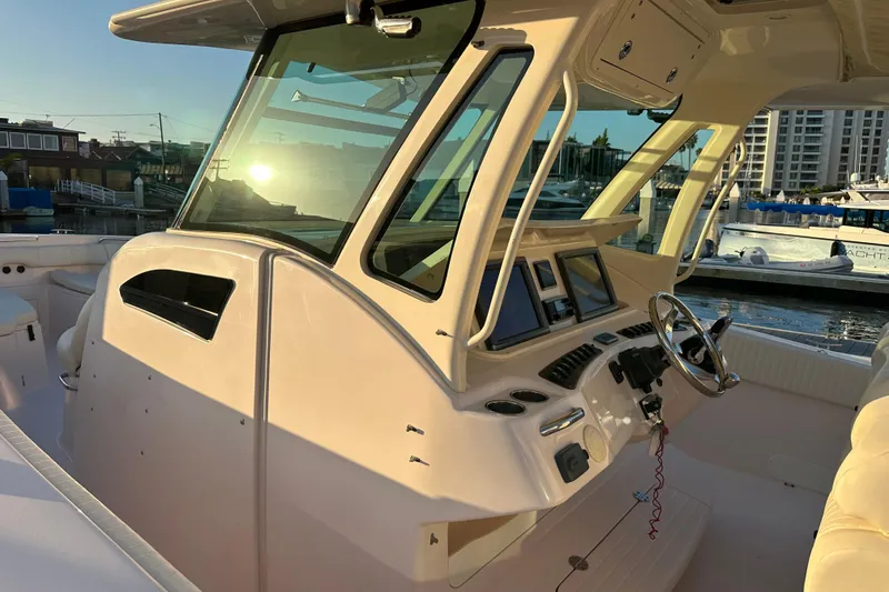 Slide: The Image of 2014 Grady-White Canyon 376 boat interior with steering wheel and control panel at marina. - 10