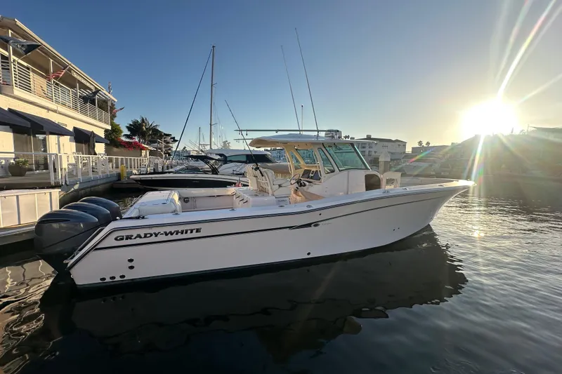 Slide: The Image of 2014 Grady-White Canyon 376 boat docked at sunset, featuring triple outboard engines. - 12