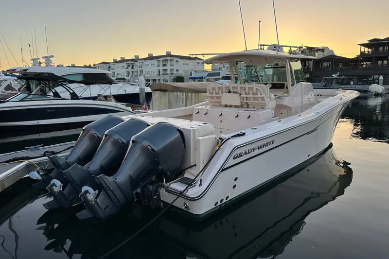 Slide: The Image of 2014 Grady-White Canyon 376 boat docked at sunset, featuring triple outboard engines. - 13