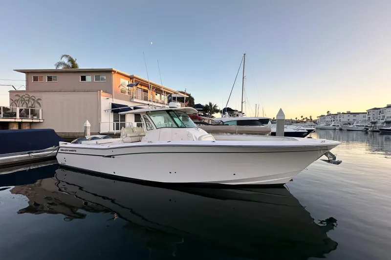 Slide: The Image of 2014 Grady-White Canyon 376 boat docked in a serene marina at sunset. - 19