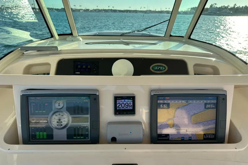 Slide: The Image of 2014 Grady-White Canyon 376 dashboard with navigation and control screens, overlooking the water. - 21