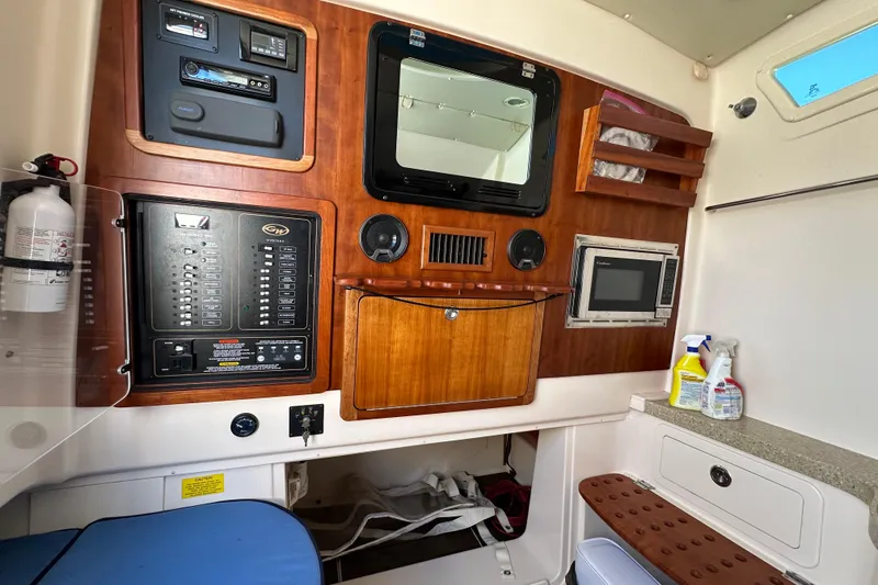 Slide: The Image of 2014 Grady-White Canyon 376 cabin interior with control panel and storage. - 23