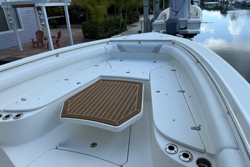 Slide: The Image of 2016 Boston Whaler 320 Outrage boat deck with seating and table, docked by waterfront. - 3