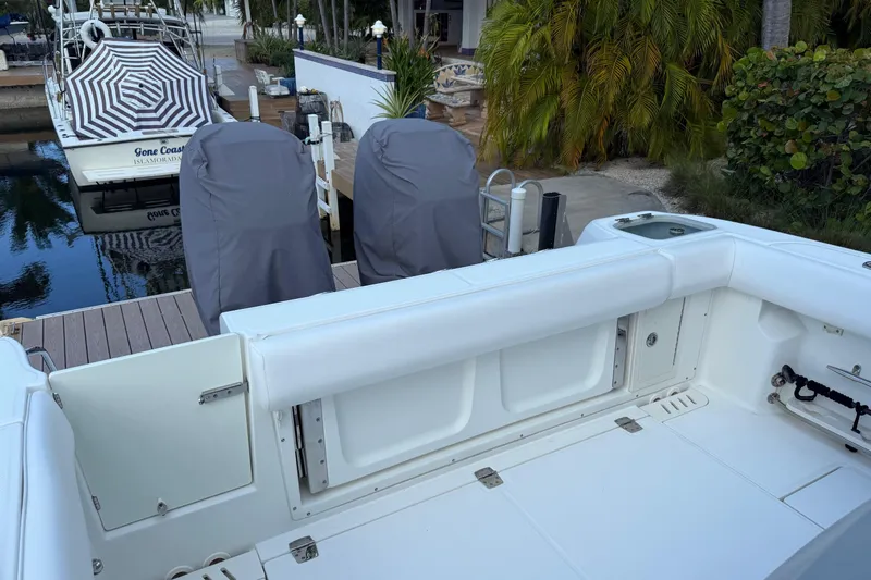 Slide: The Image of 2016 Boston Whaler 320 Outrage at dock, featuring covered seats and spacious deck. - 6