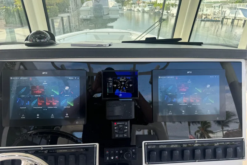 Slide: The Image of Helm of 2016 Boston Whaler 320 Outrage with dual navigation screens and compass. - 8