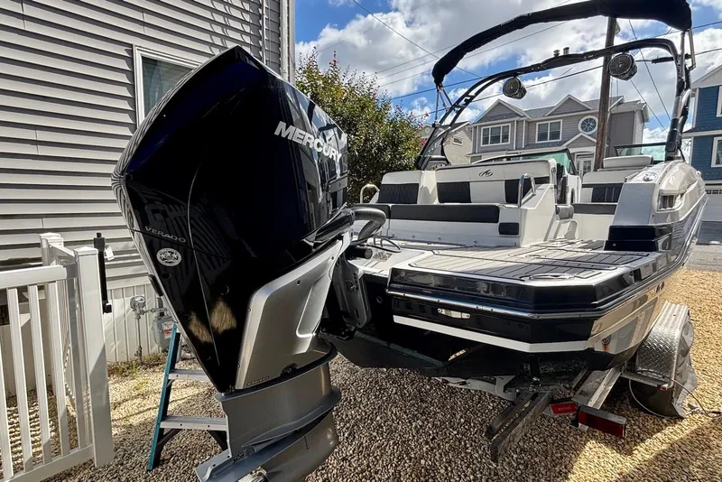 Slide: The Image of 2021 Monterey M-65 boat with Mercury Verado engine, parked on a trailer in a residential area. - 17