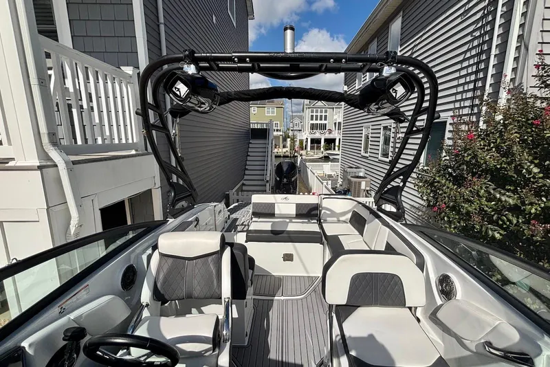 Slide: The Image of 2021 Monterey M-65 boat with sleek interior, docked between houses under a clear sky. - 4