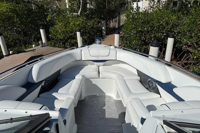 Slide: The Image of 2015 Formula 310 Bowrider with spacious white seating, docked near lush greenery. - 3