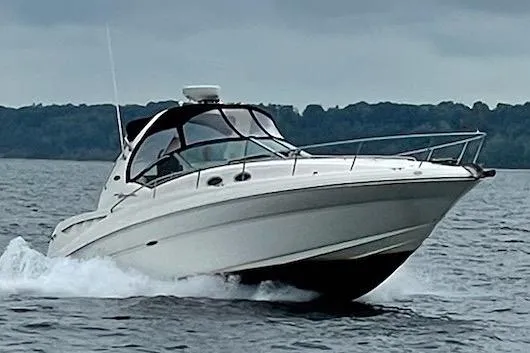 Slide: The Image of 2003 Sea Ray 320 Sundancer cruising on a lake under cloudy skies. - 0