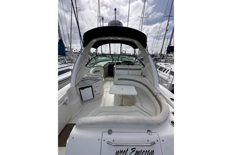 Slide: The Image of 2003 Sea Ray 320 Sundancer yacht interior with seating and table, docked at marina. - 10