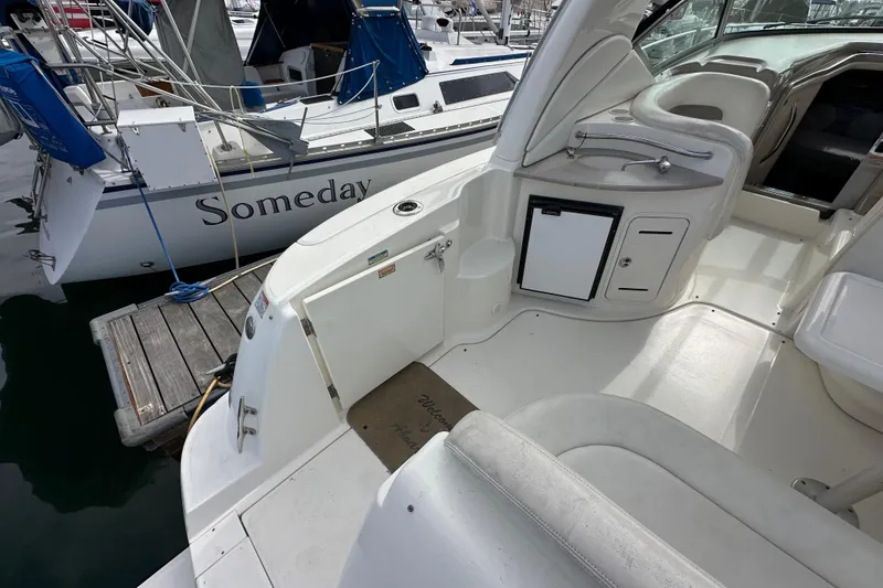 Slide: The Image of 2003 Sea Ray 320 Sundancer boat interior with docked sailboat in marina. - 11
