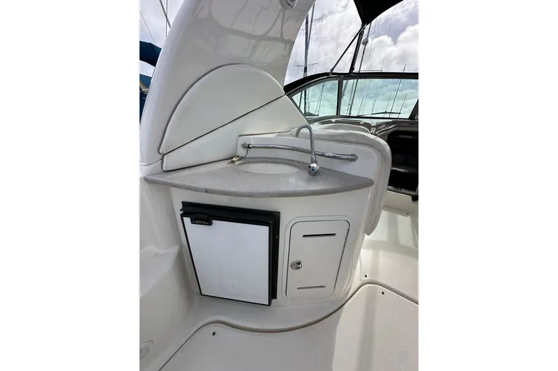 Slide: The Image of 2003 Sea Ray 320 Sundancer cockpit with sink and mini fridge. - 13