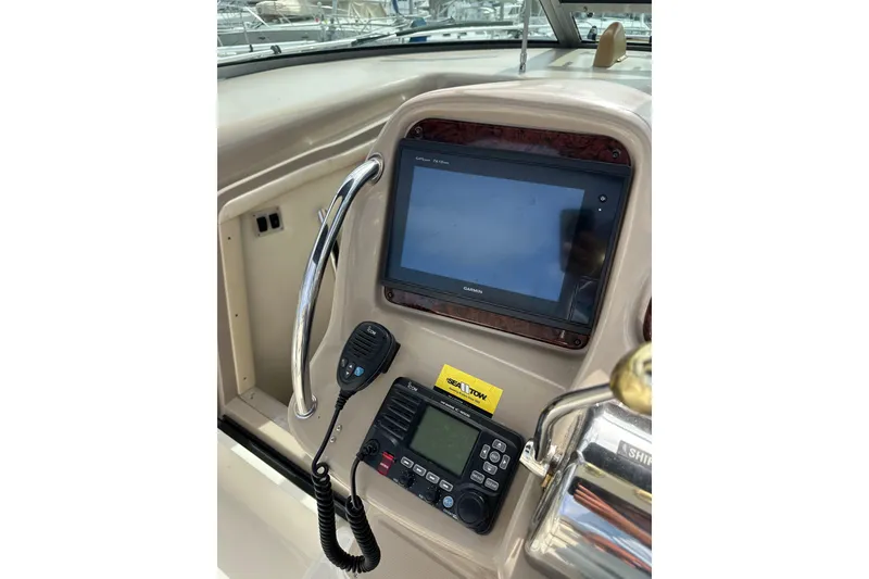 Slide: The Image of 2003 Sea Ray 320 Sundancer helm with Garmin display and communication equipment. - 19