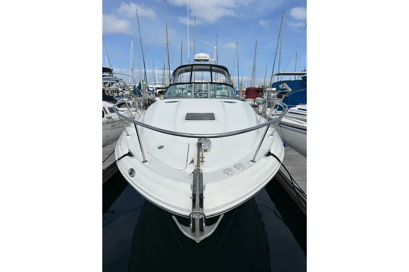 Slide: The Image of 2003 Sea Ray 320 Sundancer docked at marina, front view with clear sky. - 2