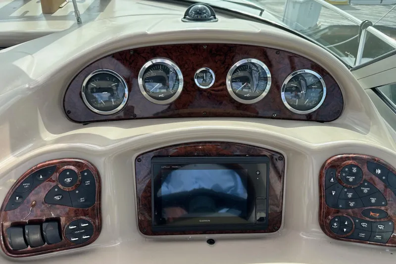 Slide: The Image of Dashboard of a 2003 Sea Ray 320 Sundancer boat with gauges and controls. - 21