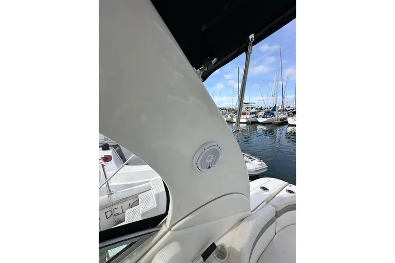 Slide: The Image of 2003 Sea Ray 320 Sundancer interior with marina view, featuring sleek design and speaker system. - 24